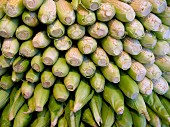 A stack of corn cobs at a market