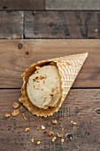 A scoop of peanut ice cream in an ice cream cone