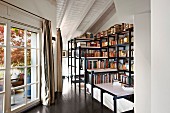 Large bookcases built over head of stairwell on landing