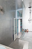 Futuristic shower platform with glass screen in silver-painted bathroom with sunburst clock