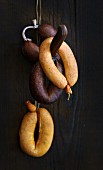 Sausages on a hook against a wooden wall