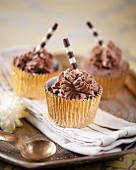 Chocolate cupcakes with striped chocolate wafer rolls