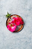 Pink rose petals on a metal plate