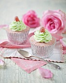 Cupcakes decorated with strawberry cream, mint frosting and jelly sweets