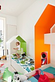 Massgefertigte Häuschen über Kinderbetten, innenseitig farbig gestrichen, kleines Kind beim Spielen