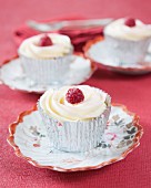 Cupcakes decorated with white chocolate and raspberries