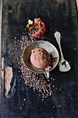 A scoop of chocolate ice cream with cocoa nibs