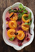 Poached peaches with cherries, lemon zest, mint and vanilla pods