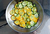 Courgette and leeks being steamed in a pan