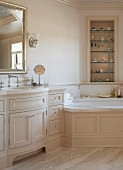 Elegant country-house bathroom with corner bathtub and fitted washstand