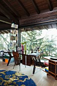 Retro desk in front of glass wall in converted attic with view into garden