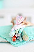 Pastel wooden spoons tied with rubber band on lacy turquoise doily