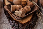 Wine and champagne corks in a wooden bowl on a piece of wood