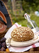 Wholemeal bread with oats on a wooden plate in a garden
