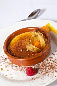 Crème brûlée with cocoa powder, physalis and raspberries