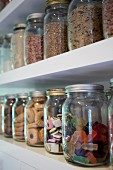 Jars of sweets and biscuits on white shelves