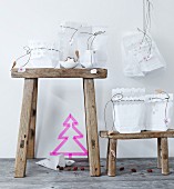 Advent calendar made from white paper bags with cut-out trim and cords with love-heart pendants