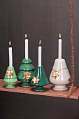 Festive, suspended arrangement of four Advent candles on copper-coloured board