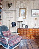 Apothecary cabinet in reading corner of study with wood-panelled walls