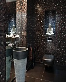 Guest toilet with elegant, shimmering, brown and black mosaic tiles, Buddha figurine and pedestal sink