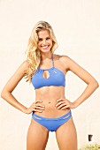 Junge blonde Frau in blauem Bikini