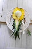 Pineapple ice cream with rosemary served in a halved pineapple