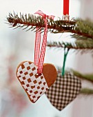 Gingerbread heart decorated with chequered icing hung on Christmas tree