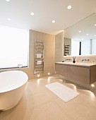 Free-standing bathtub and recessed spotlights in floor and ceiling in bright bathroom