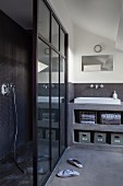 Grey bathroom with separate shower area and open-fronted concrete shelves with integrated sink