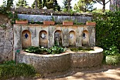 Old stone fountain with pools against garden wall (Villa Cimbrone)