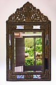Reflections in antique mirror with ornate metal frame on wall (Villa Cimbrone)