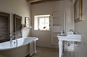 Free-standing vintage bathtub and sink on china legs in rustic bathroom