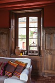 Sofa in grand interior with half-height wood panelling and window niche