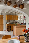 Wooden furnishings in open-plan kitchen of renovated farmhouse