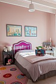 Bed with modern headboard and valance in child's bedroom with pink walls