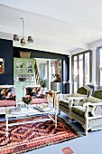 Wohnzimmer mit Vintage Sitzmöbeln und Couchtisch auf Teppich