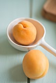 An apricot with a white porcelain spoon
