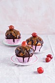 Muffins with chocolate glaze, caramel sauce and gooseberries