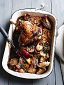 Roasted leg of lamb with onions in a roasting tin