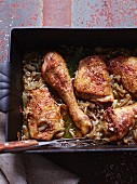 Tandoori chicken legs in an onion sauce in a roasting tin