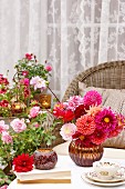 Summery terrace with wicker chair & vase of dahlias on table