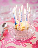 A cupcake with vanilla butter cream and birthday candles