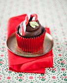 A chocolate cupcake decorated with a candy cane