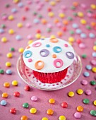 A cupcake decorated with colourful fondant icing