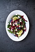 Radicchio salad with rocket, feta cheese, lemons and blueberries (seen from above)