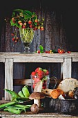 Waldpilze, junge Erbsen und Erdbeeren auf altem Holztisch