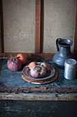 A rustic arrangement with a pewter jug, a salt shaker and beetroots on pewter plate