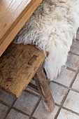 Pale sheepskin blanket on wooden bench