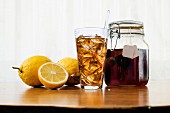 Iced tea in a glass and a flip-top jar next to lemons