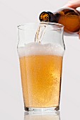 Lager being poured from a bottle into a glass